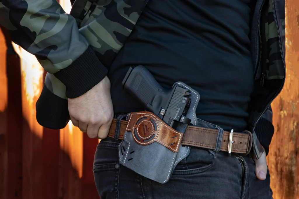 Man with a pistol in his holster that has a red dot sight